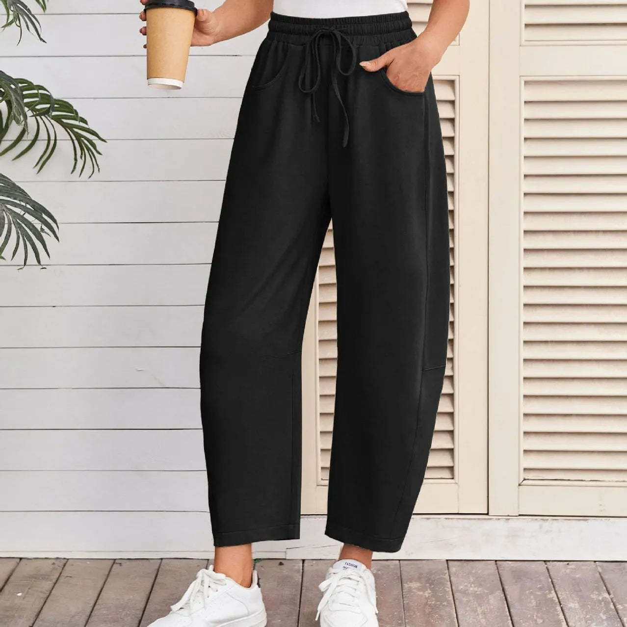 Women's loose grey cropped sweatpants with drawstring waist and side pockets on a hanger.