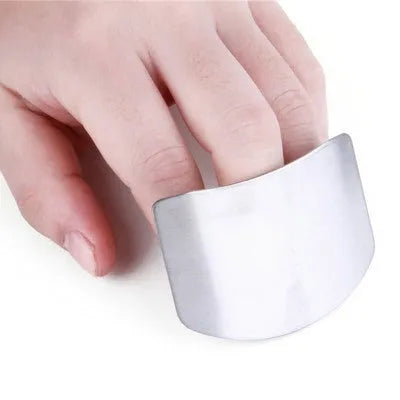Stainless steel finger guard for protecting fingers when cutting vegetables on a chopping board.