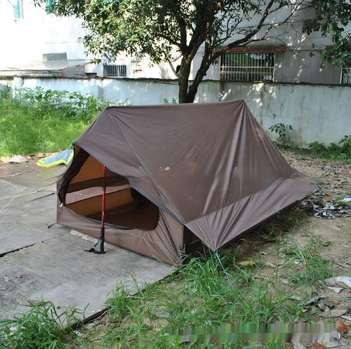 Brown or white A-line hiking tent without poles, supported by hiking canes