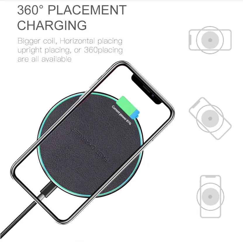 Black Qi wireless charging pad for iPhone 11 placed on a wooden surface.