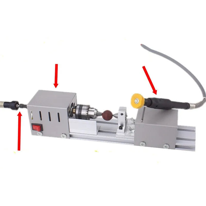 Silver metal mini manual woodworking lathe with carving knives on a workbench.