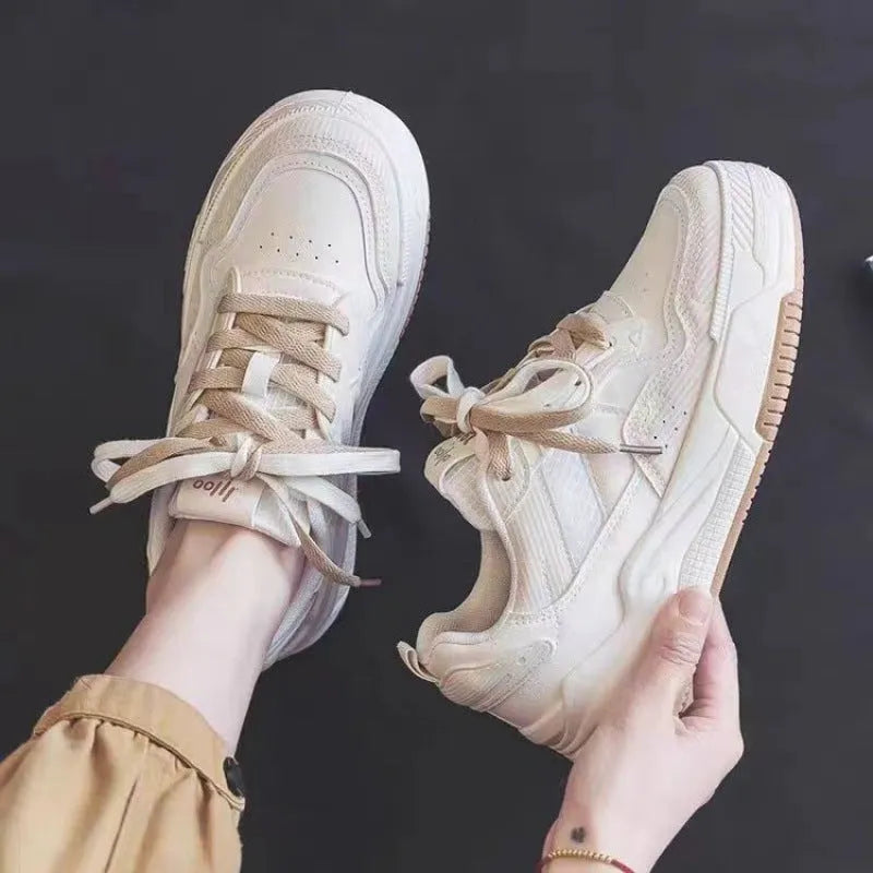 Beige and pink low-top platform sneakers with a rubber sole on a white background