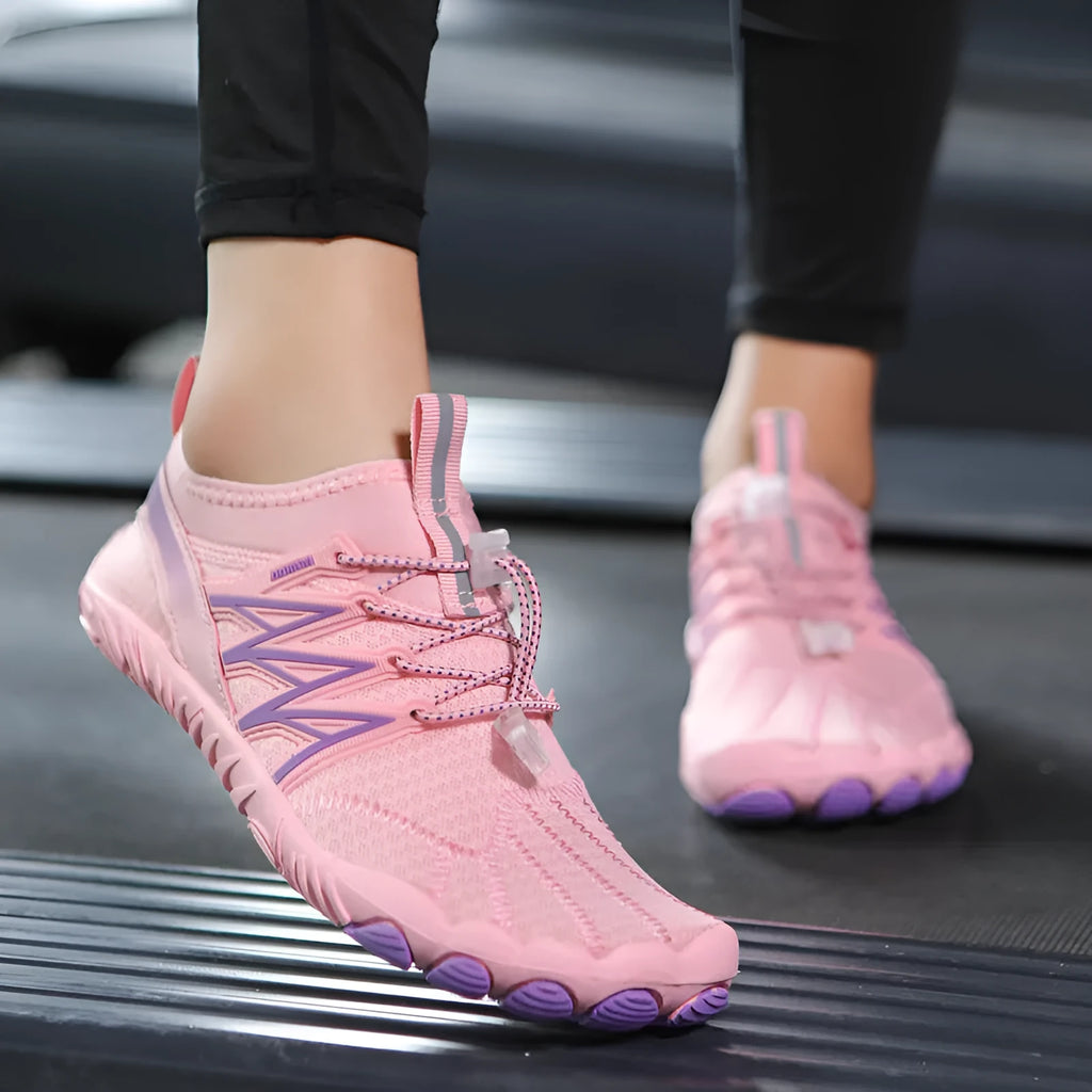 Low-top striped training sneakers with a flat rubber sole, shown in various colours including black and grey orange.