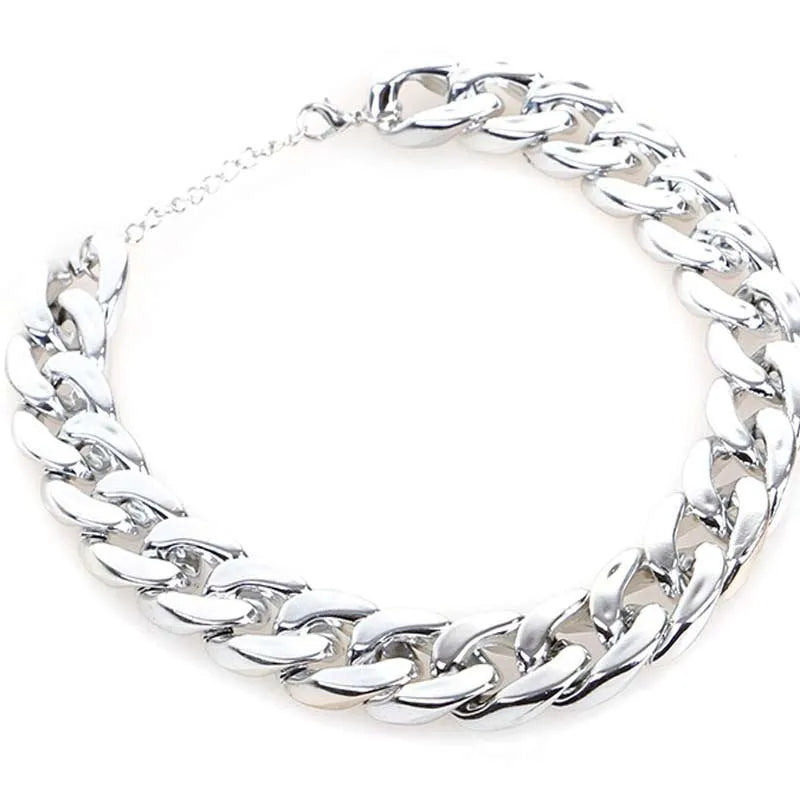 Gold geometric buckle dog chain collar on a small dog, showing twisted link design.