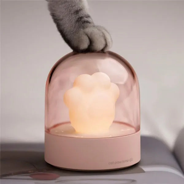 Grey or pink cat paw shaped USB rechargeable night light with musical functions on wooden desktop
