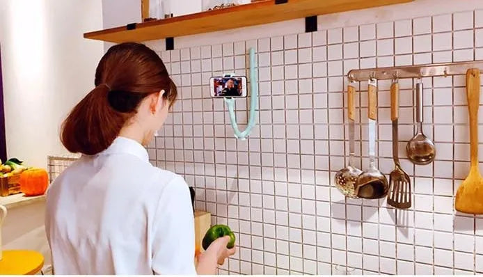 Flexible black rubber phone holder with suction cup extended, showing 360° rotation joint next to a mobile phone.