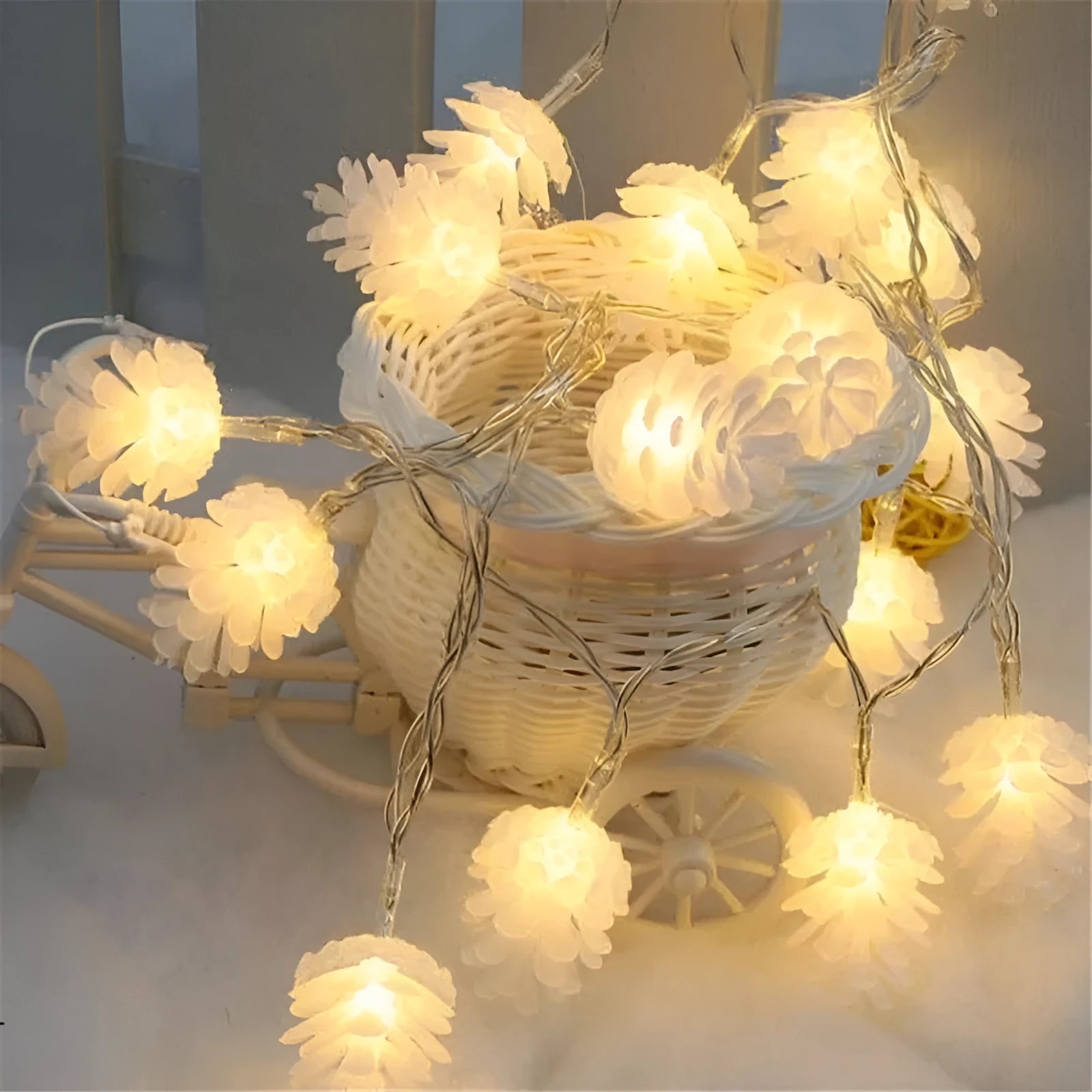 Warm white plastic pine cone LED light string powered by batteries on a dark background.