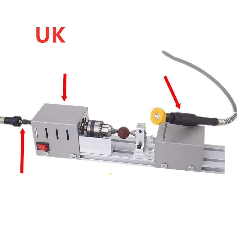Silver metal mini manual woodworking lathe with carving knives on a workbench.