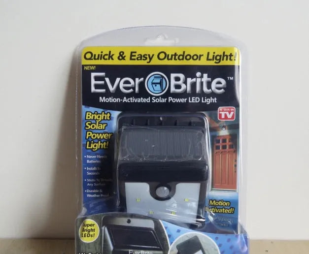 Four white solar LED security lights with motion sensors mounted on outdoor wall