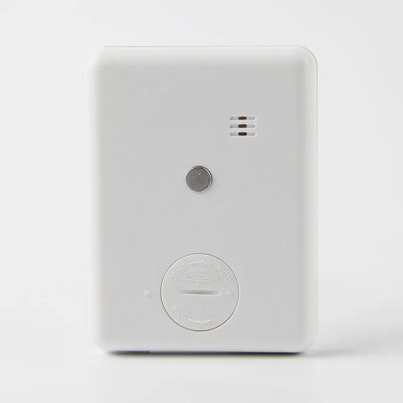 Black and white digital kitchen timer with LCD screen and magnetic back on a fridge
