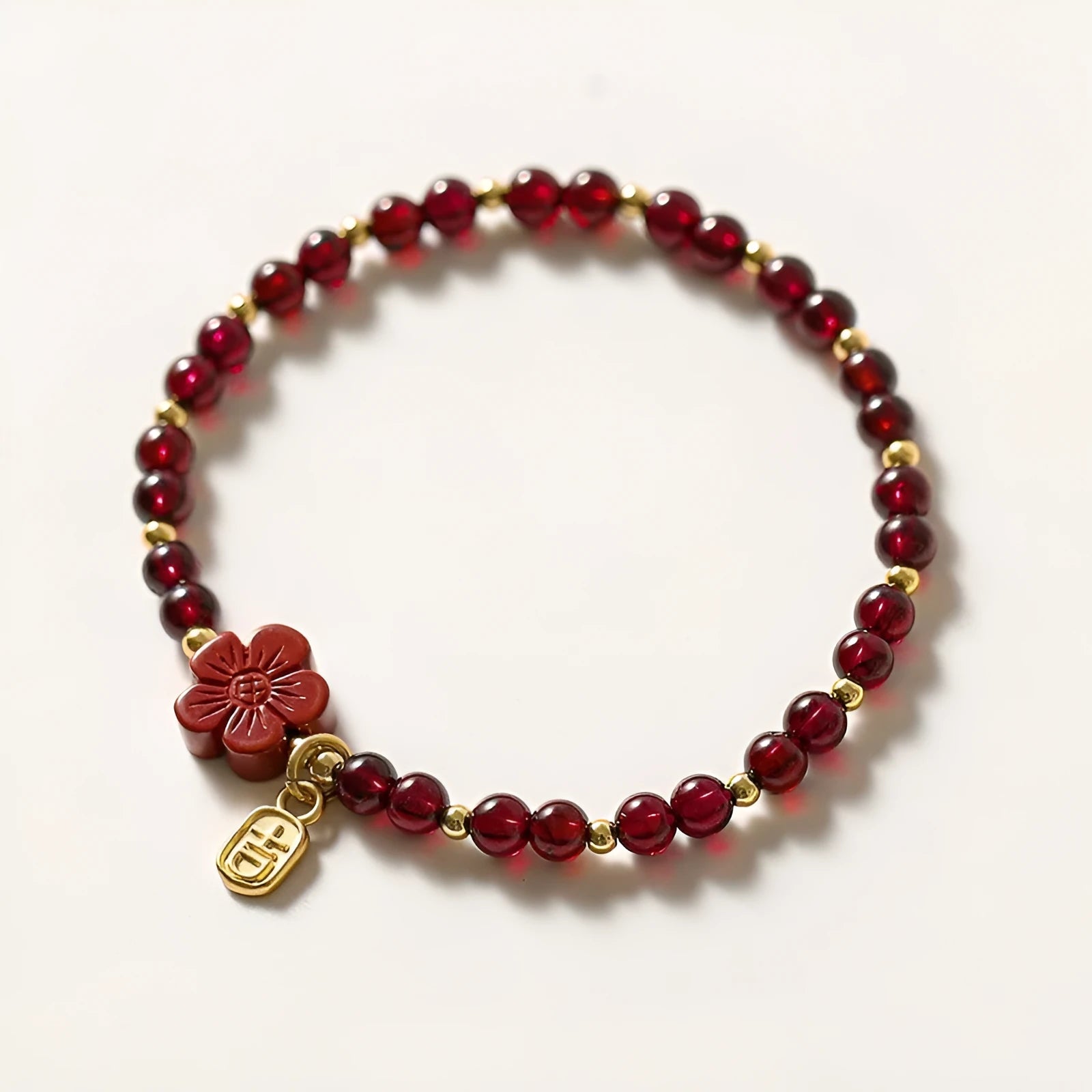 Women's geometric braided rope bracelet with freshwater pearls, amethyst, pomegranate, and red beads.
