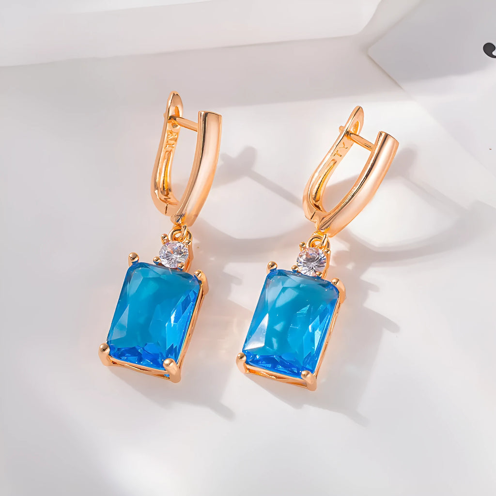 A pair of square geometric stud earrings with a gold electroplated finish on a copper base.