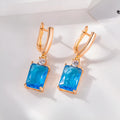 A pair of square geometric stud earrings with a gold electroplated finish on a copper base.