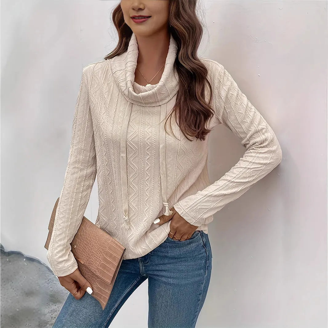 Apricot coloured pullover sweater with a drawstring hood and long sleeves laid flat.