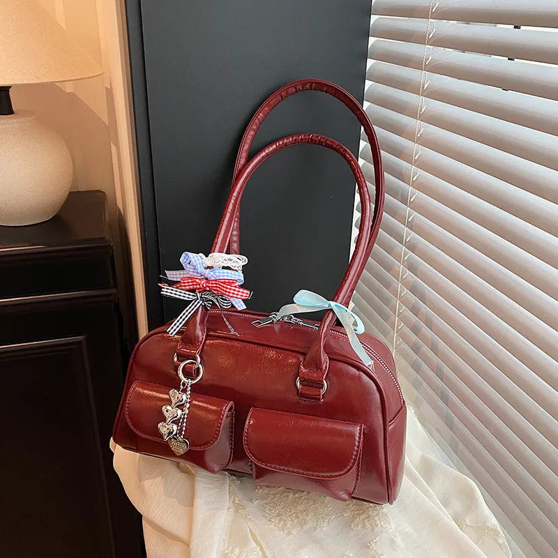 Brown PU leather retro pillow bag for women with a flap closure and double shoulder strap.
