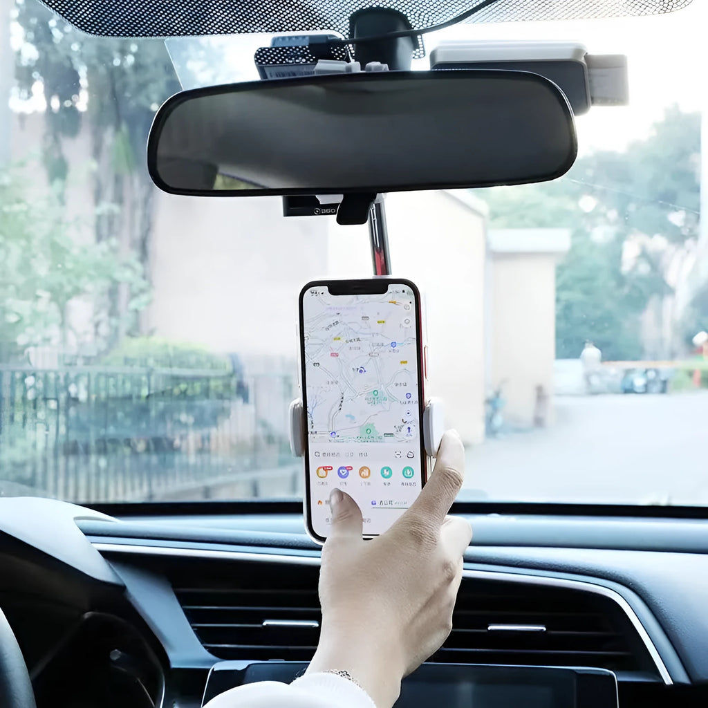Black ABS plastic mobile phone bracket mounted on a car rearview mirror, holding a smartphone.