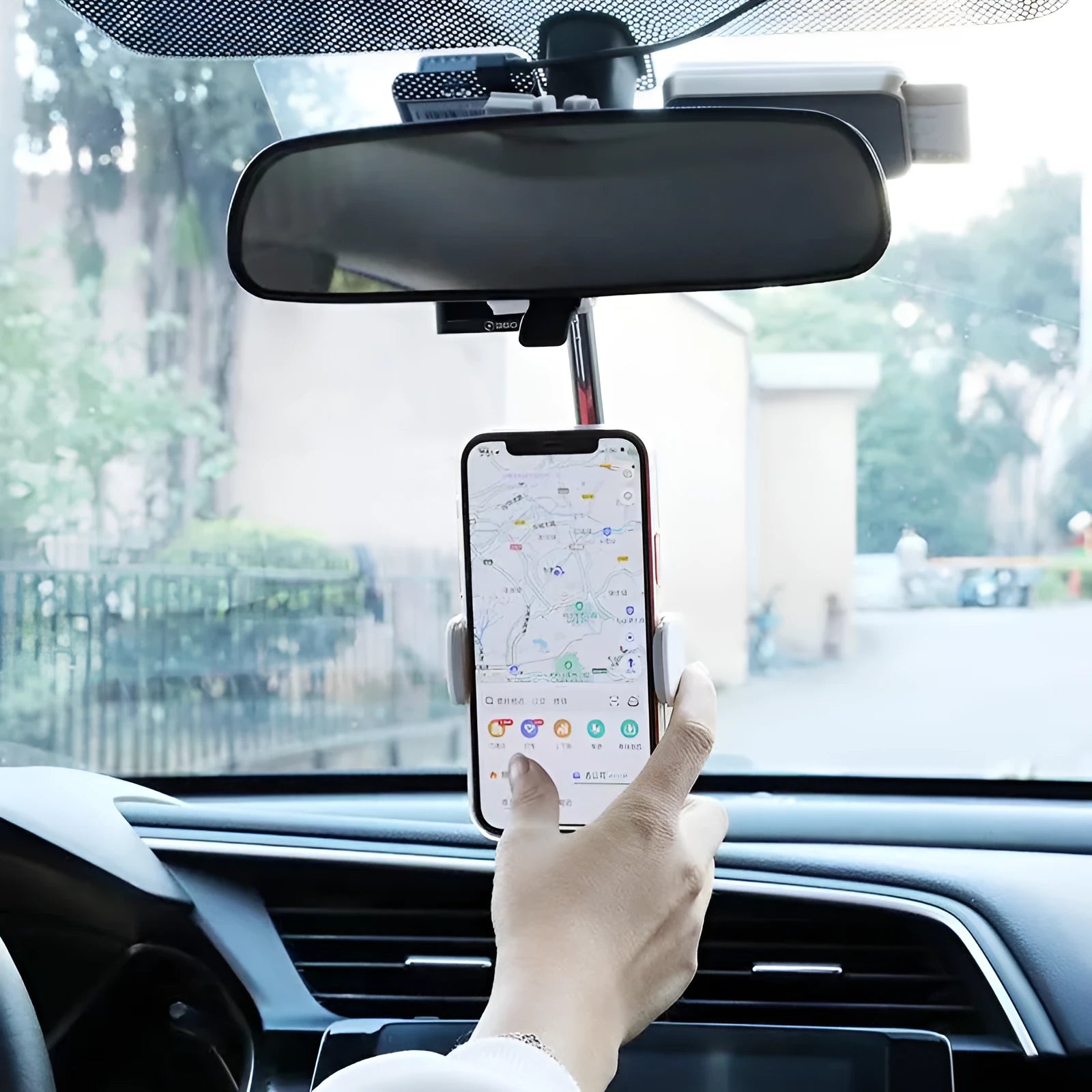 Black ABS plastic mobile phone bracket mounted on a car rearview mirror, holding a smartphone.