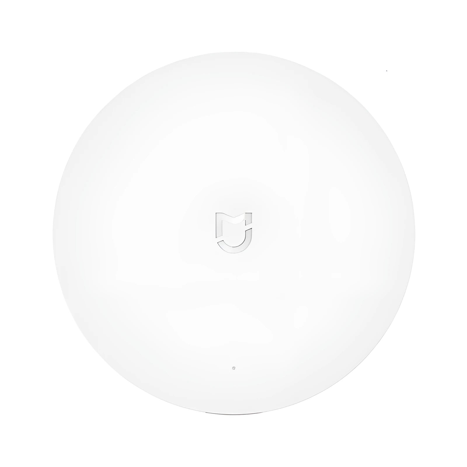 White circular Xiaomijia smart home gateway hub with UK plug on a table.