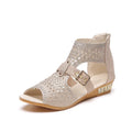 Women's beige flat sandals with a back zipper and low wedge heel on a white background.