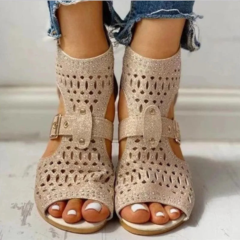 Women's beige flat sandals with a back zipper and low wedge heel on a white background.