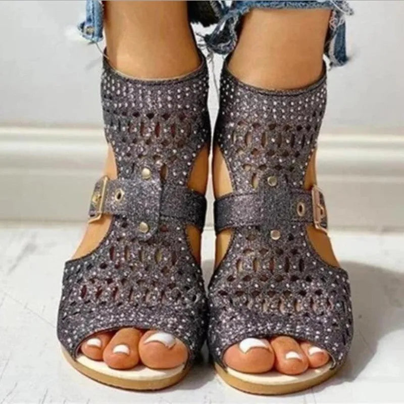 Women's beige flat sandals with a back zipper and low wedge heel on a white background.