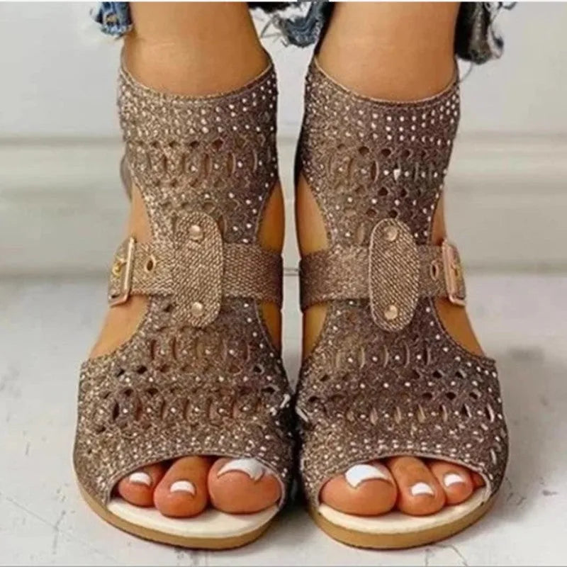 Women's beige flat sandals with a back zipper and low wedge heel on a white background.