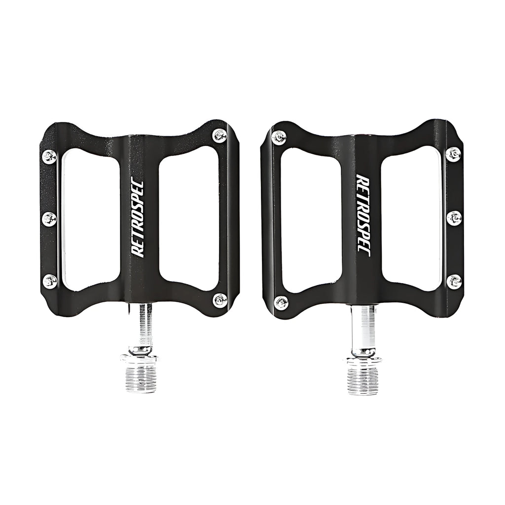 Pair of black CNC aluminium mountain bike pedals with sealed bearings and anti-skid nails on a white background