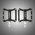 Pair of black CNC aluminium mountain bike pedals with sealed bearings and anti-skid nails on a white background