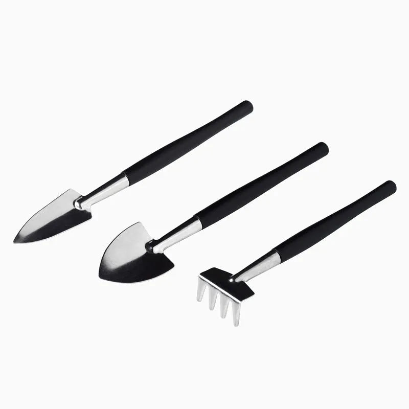 Black plastic and metal mini succulent gardening tool set with 15 pieces laid out on a square cushion.