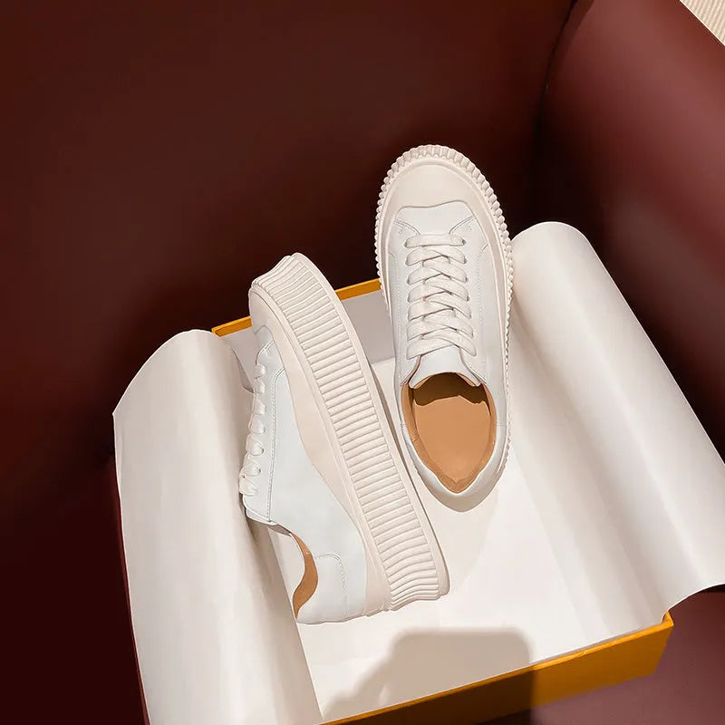 Women's black suede platform trainers with thick white soles and cross-lace design on a white background.
