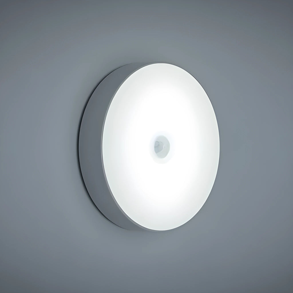 Compact round motion sensor LED night light with USB charging cable and adhesive mounting tape