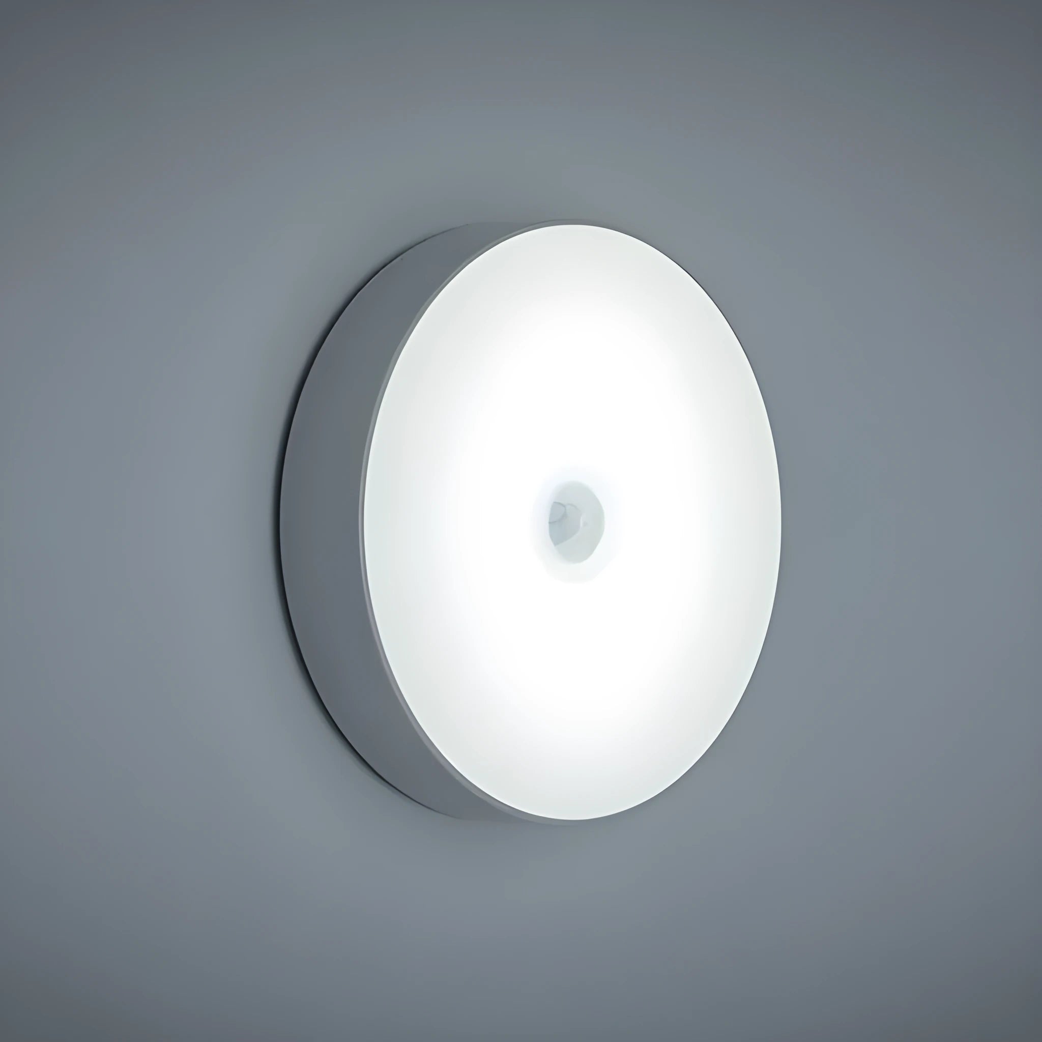 Compact round motion sensor LED night light with USB charging cable and adhesive mounting tape