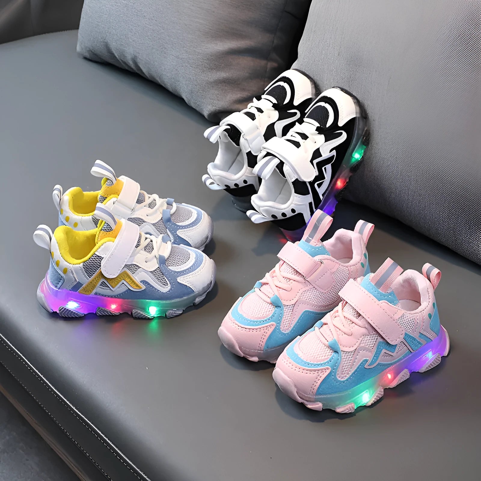 Children's light grey sneakers with mesh panels, Velcro strap, and a white rubber sole.