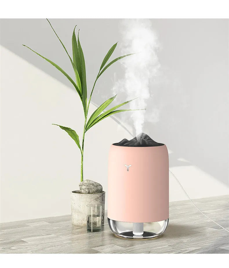 Mini columnar ultrasonic humidifier with magic flame light effect in white, blue, and pink colour options.