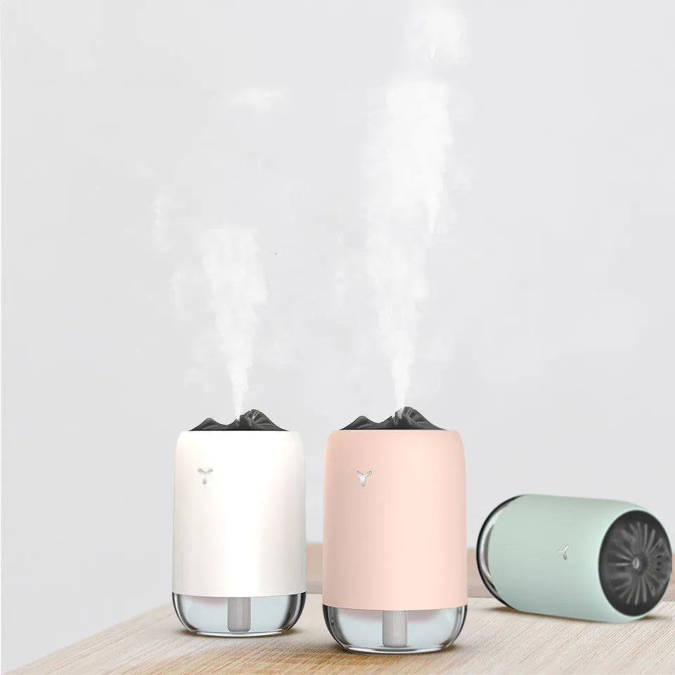Mini columnar ultrasonic humidifier with magic flame light effect in white, blue, and pink colour options.