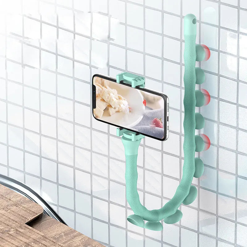 Flexible black rubber phone holder with suction cup extended, showing 360° rotation joint next to a mobile phone.