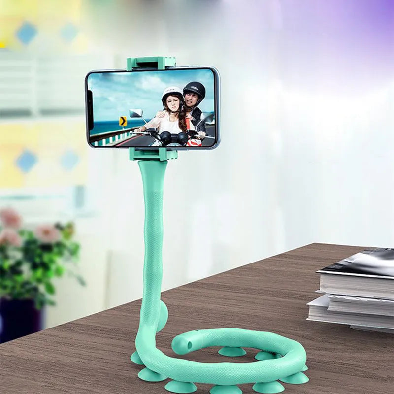 Flexible black rubber phone holder with suction cup extended, showing 360° rotation joint next to a mobile phone.