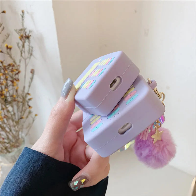 Purple silicone clamshell AirPods case with fur ball pendant for Apple wireless headphones