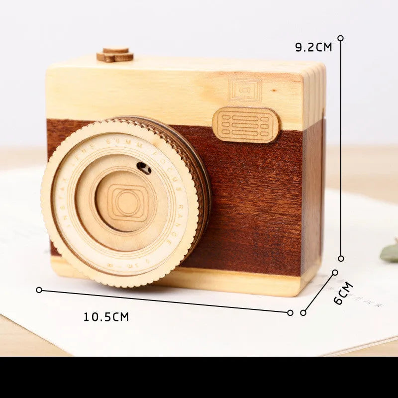 Wooden camera-shaped music box with rotating mechanism on pine wood base