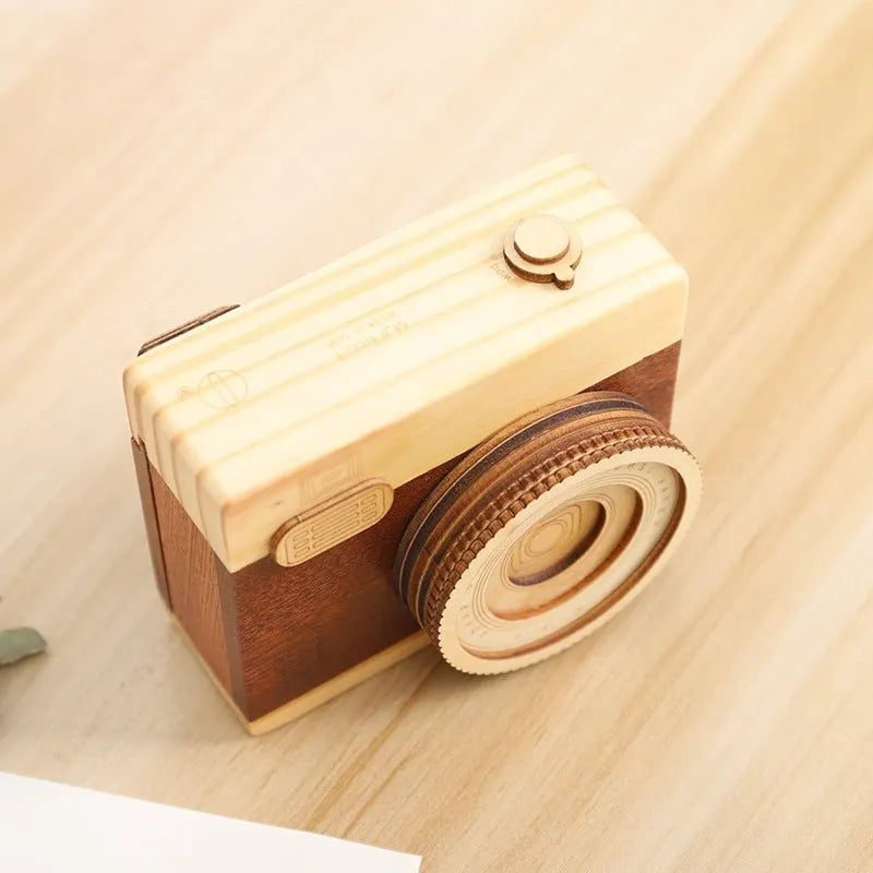 Wooden camera-shaped music box with rotating mechanism on pine wood base