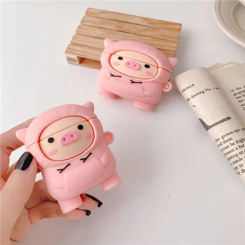 Pink silicone AirPods case with cartoon pig design, flip opening, and hook attachment