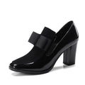 Black patent leather women's high heels with a thick square heel and rubber sole.