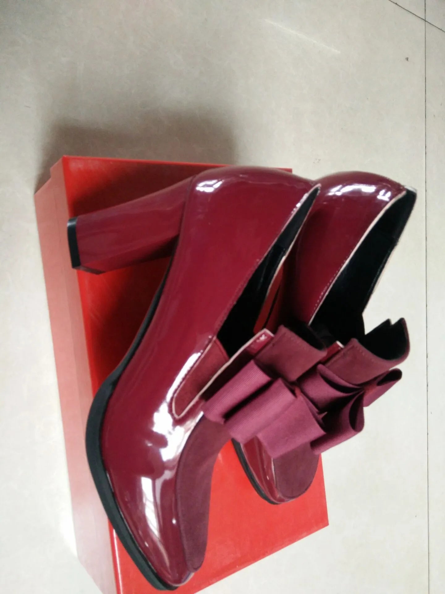 Black patent leather women's high heels with a thick square heel and rubber sole.