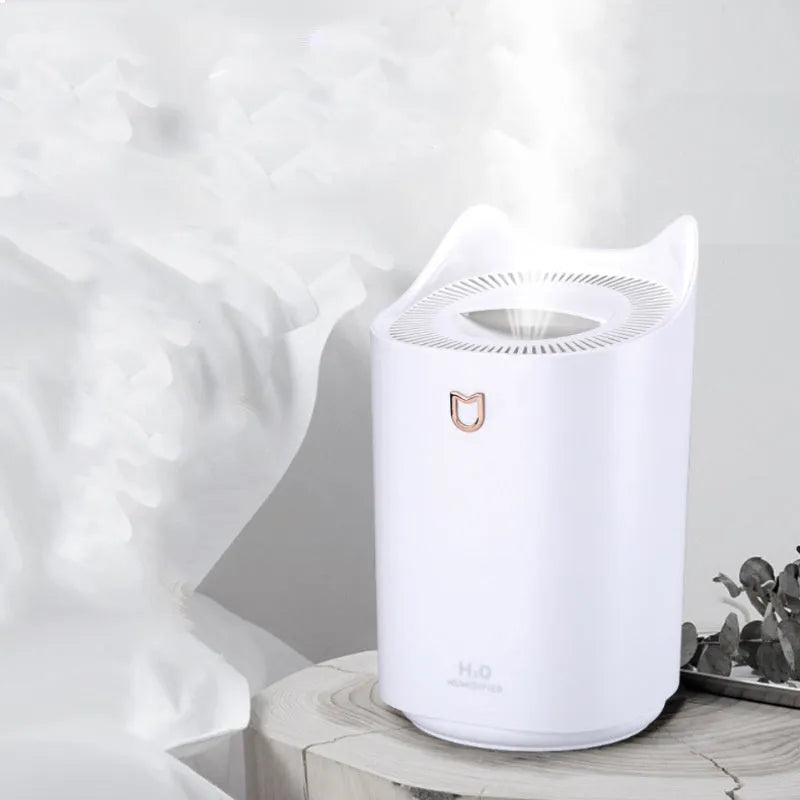 White double spray humidifier with USB cable and three mist outlets on a wooden table.
