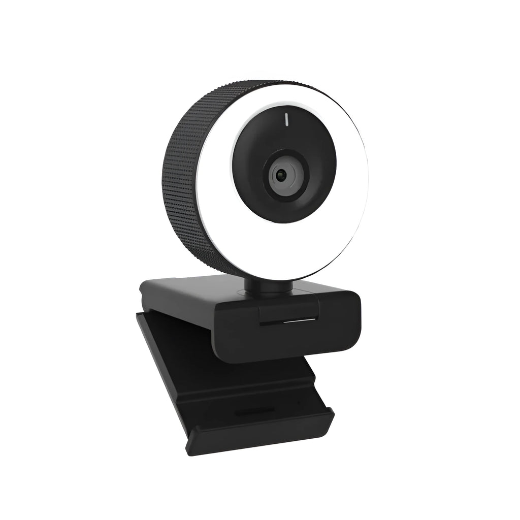Black USB webcam with a magnetic privacy cover on a desk next to a laptop.