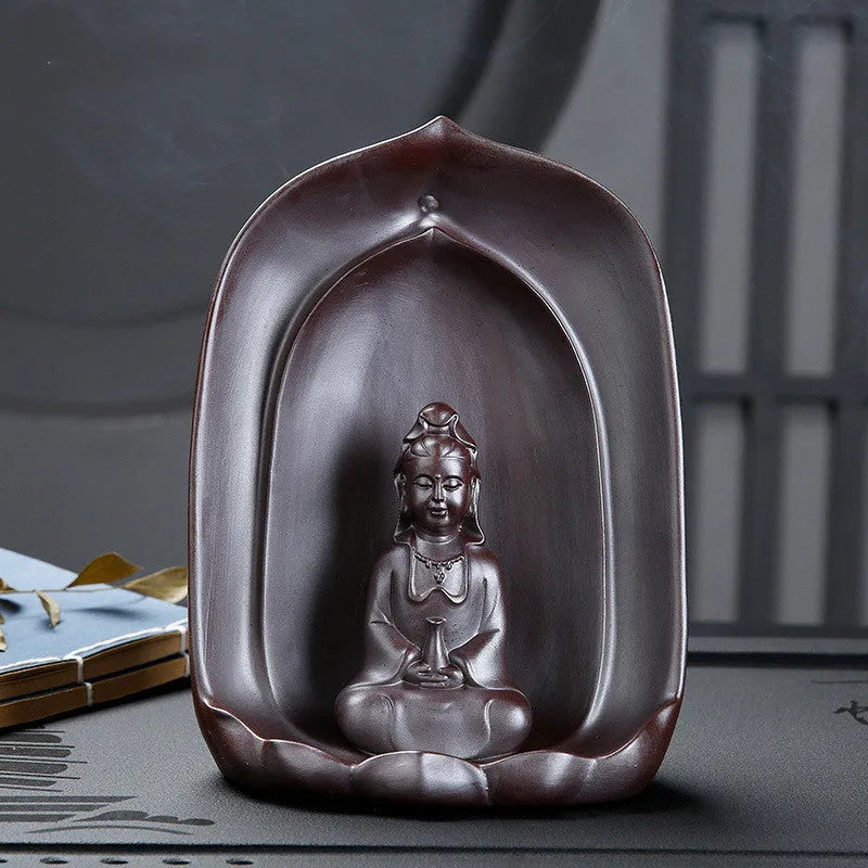 Ceramic Guanyin sitting lotus back flow incense burner with smoke cascading downward on home altar