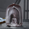 Ceramic Guanyin sitting lotus back flow incense burner with smoke cascading downward on home altar