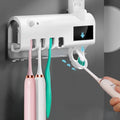 Black smart UV toothbrush steriliser and automatic toothpaste squeezer mounted on a bathroom wall.