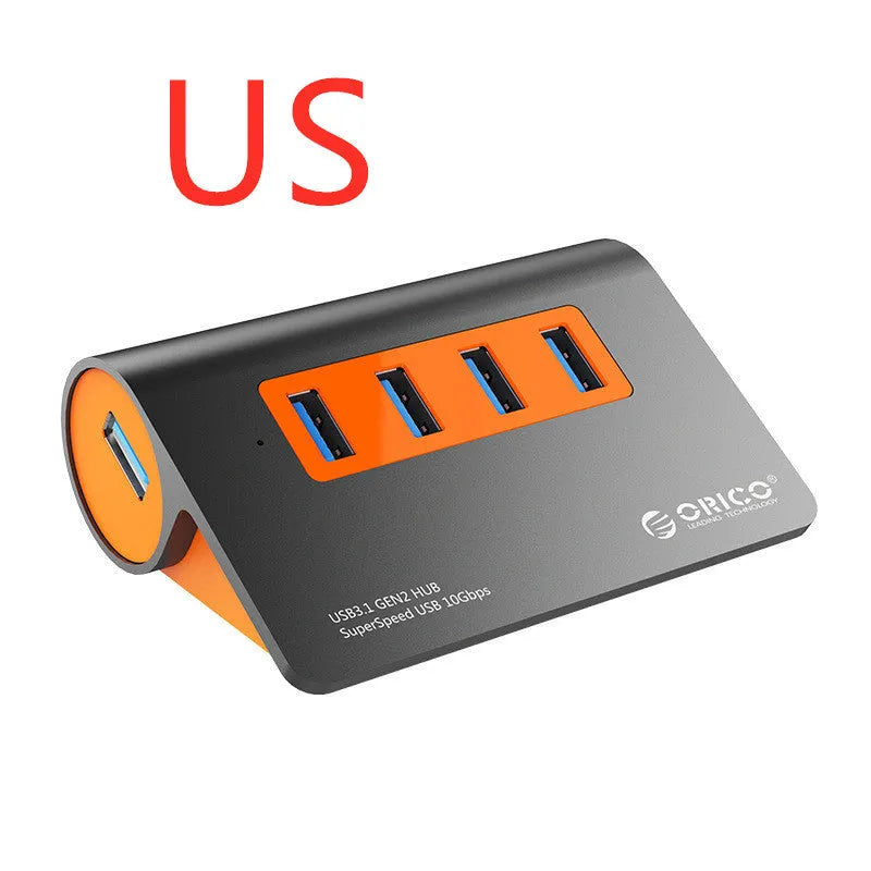 Dark grey and orange aluminium USB-C hub with four USB 3.1 ports, a DC power input, and a detachable cable.