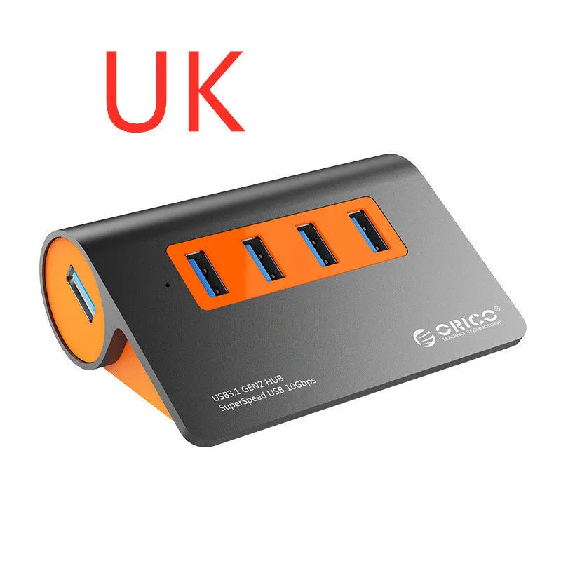 Dark grey and orange aluminium USB-C hub with four USB 3.1 ports, a DC power input, and a detachable cable.